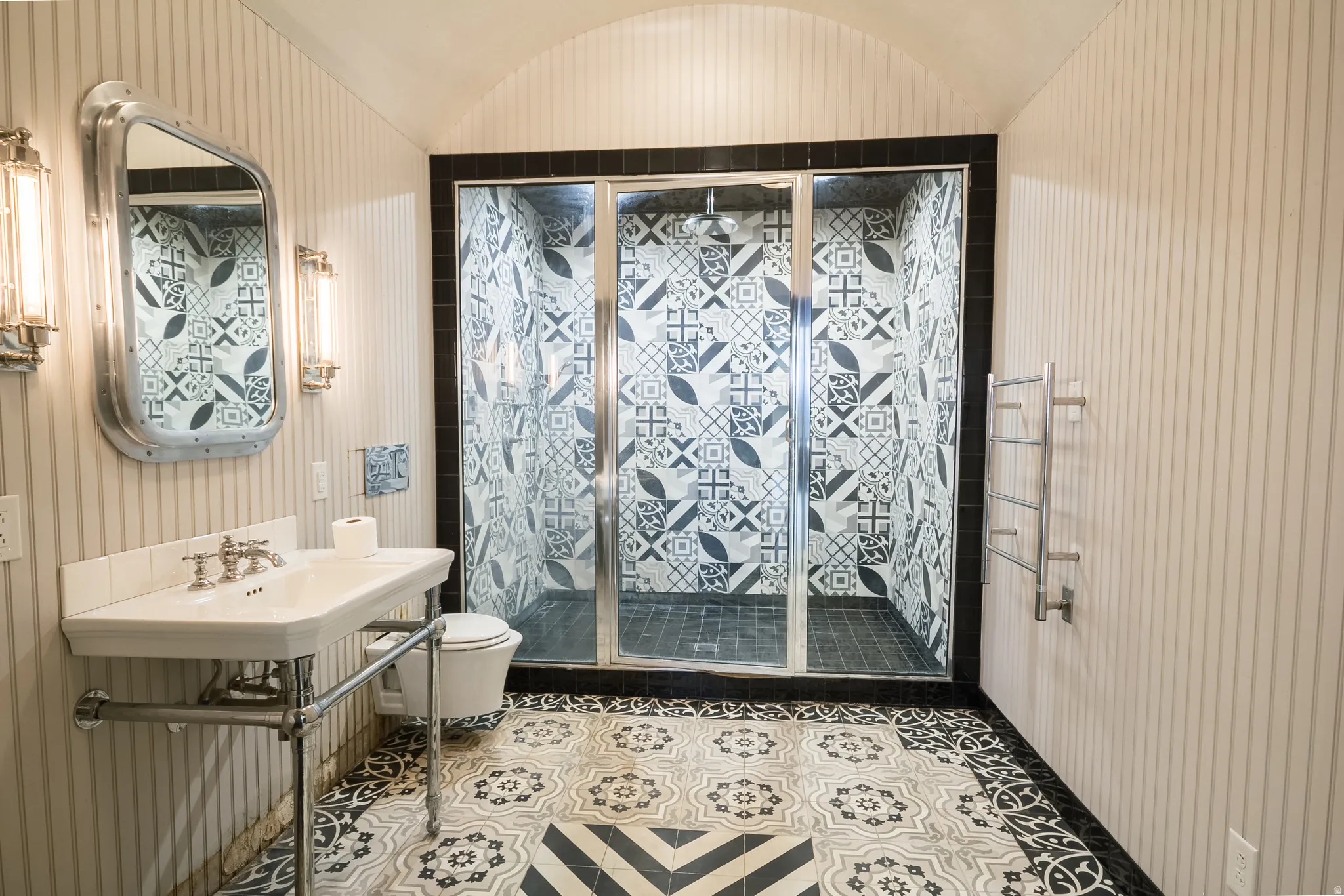 Bathroom with a shower stall and a barrel ceiling