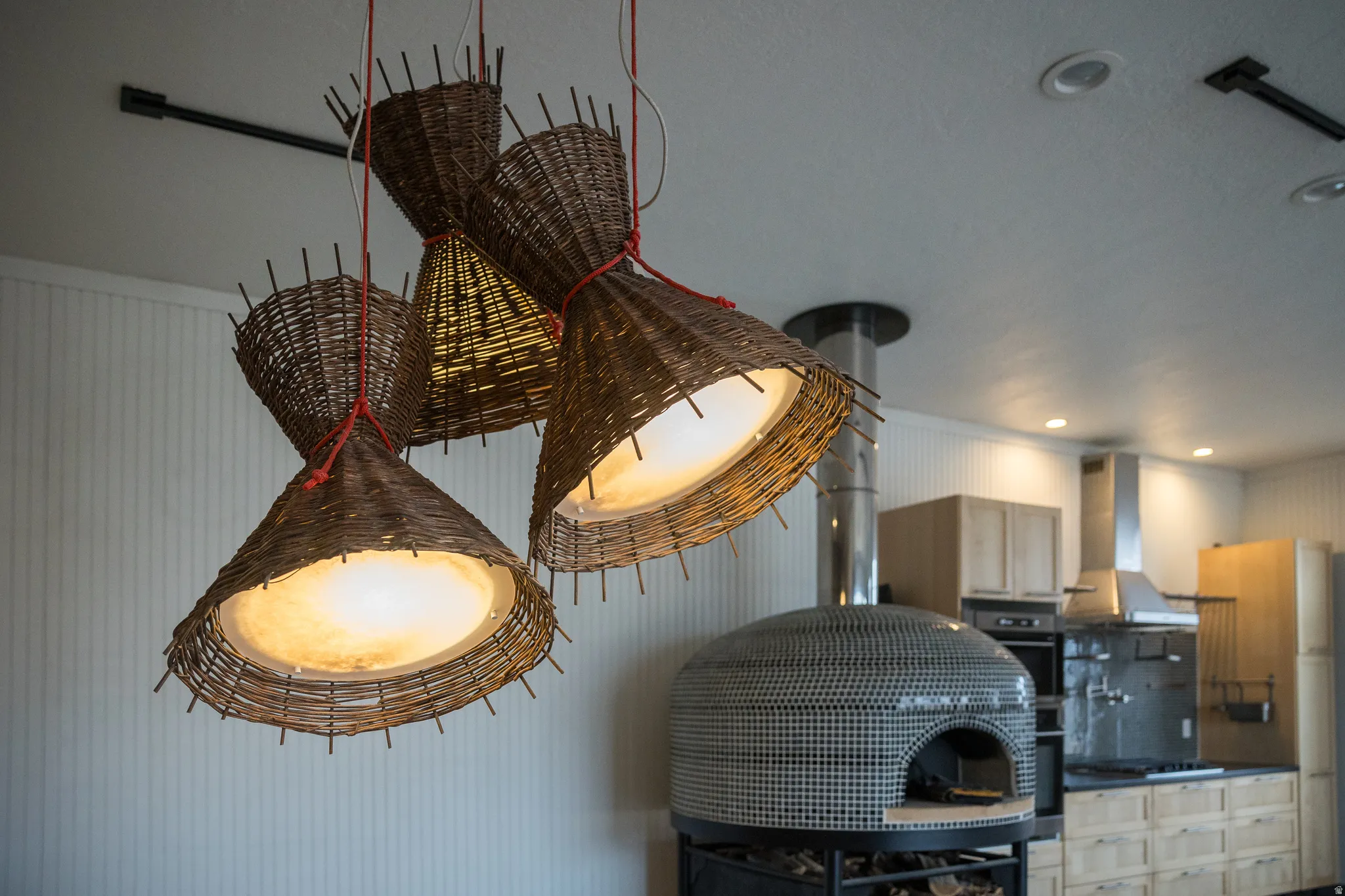 Kitchen view of wall chimney exhaust hood, black appliances, and recessed lighting