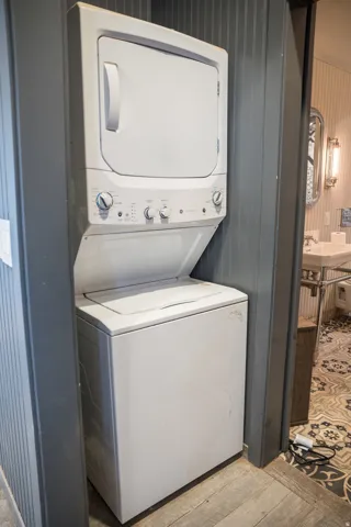 Laundry area featuring light wood-style floors and stacked washing machine and dryer