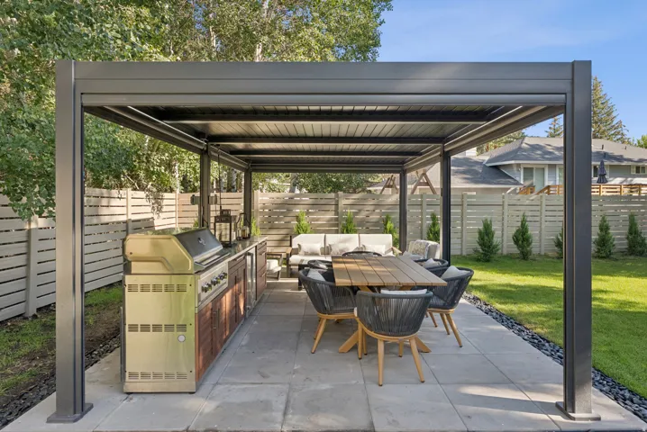Fenced backyard with an outdoor kitchen, a patio area, and an outdoor living / dining area