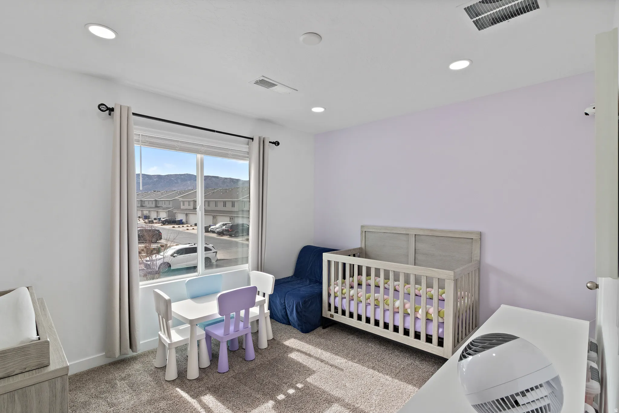 Carpeted bedroom featuring a nursery area, a mountain view, and recessed lighting