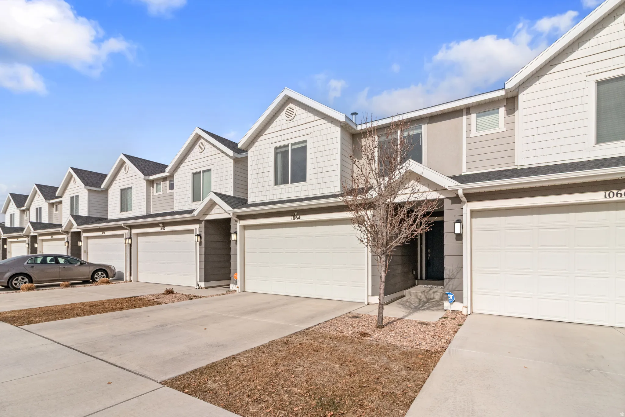 View of front of home with concrete driveway, a residential view, and an attached garage