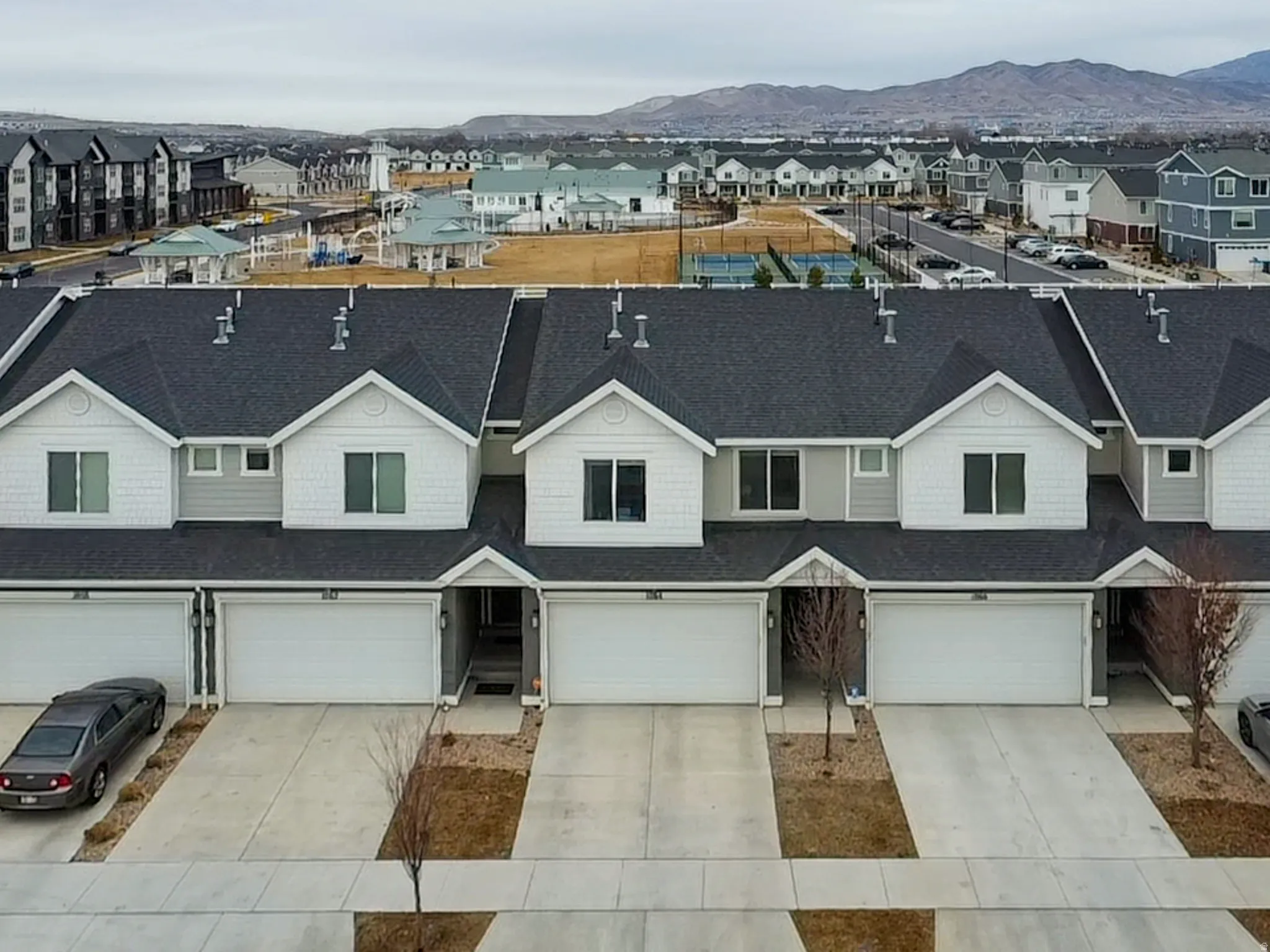 Traditional home with a residential view, driveway, roof with shingles, and a mountain view