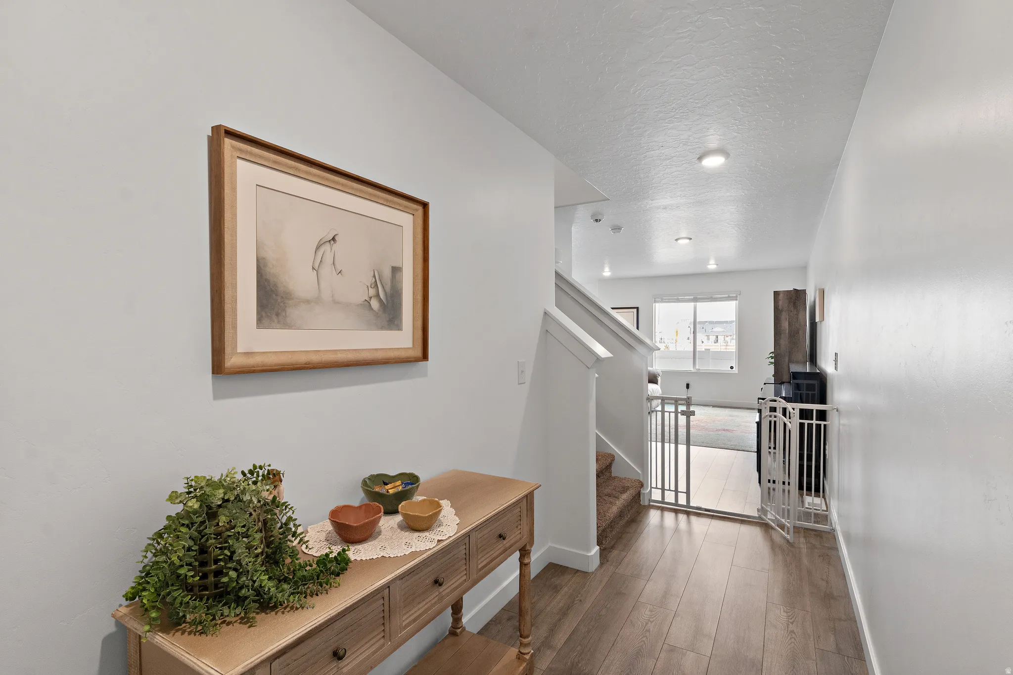 Hall featuring wood finished floors and a textured ceiling