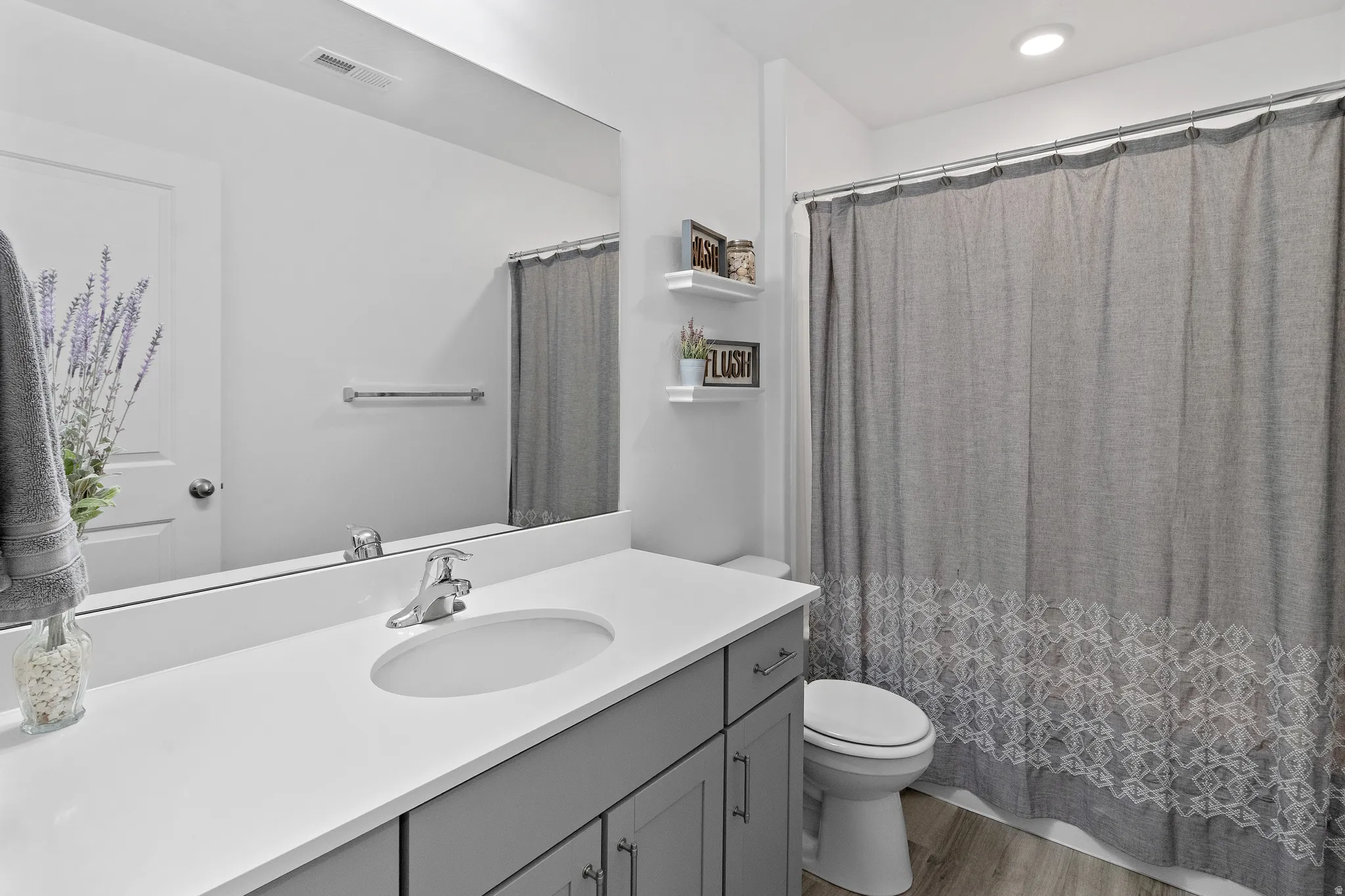 Full bathroom featuring a shower with curtain, vanity, light wood finished floors, and recessed lighting