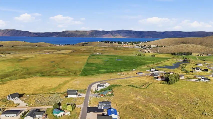 Expansive open fields with distant water frontage and surrounding mountains