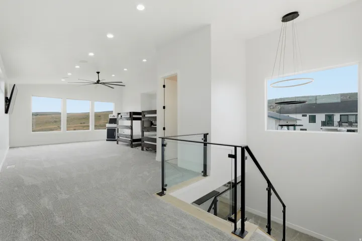 Open loft area featuring recessed lighting, a large ceiling fan, and carpeted flooring