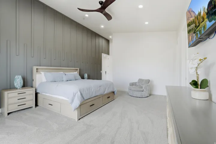 Accent wall with vertical paneling, recessed lighting, ceiling fan, and light-toned carpeting