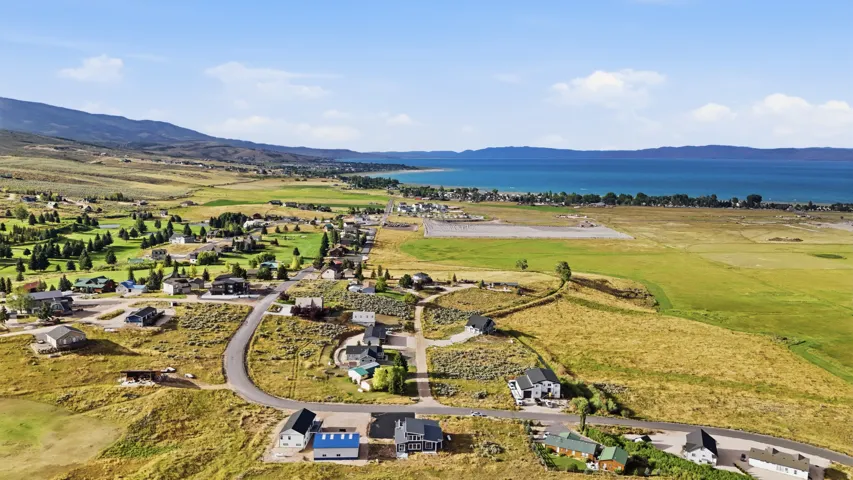 Expansive natural landscape with a large body of water, distant mountains, and scattered residential properties