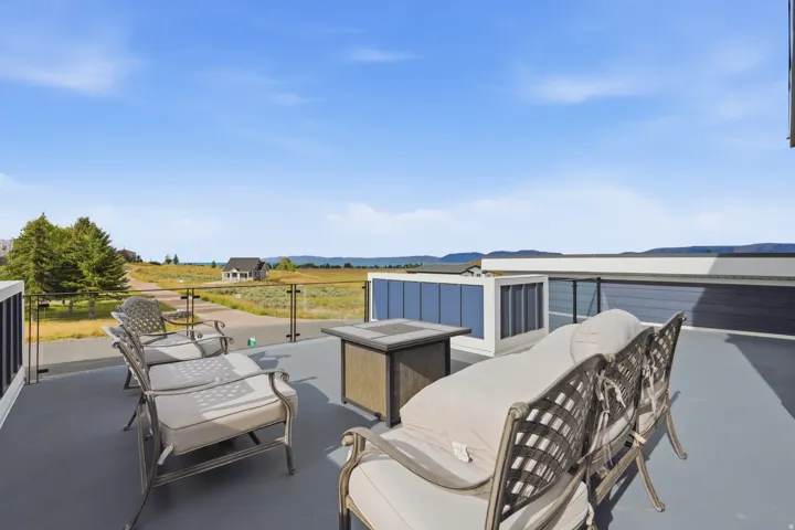 Rooftop deck featuring a glass railing, mountain scenery, and a painted floor surface