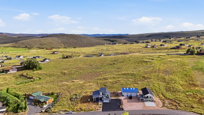 Expansive natural landscape with distant rolling hills and scattered residential properties