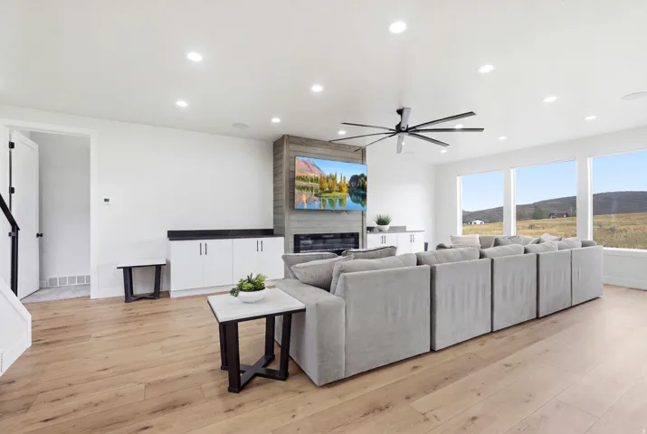 Wide-plank wood-finish flooring, recessed lighting, and a modern ceiling fan