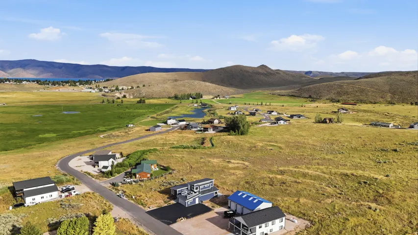 Expansive open landscape featuring a distant body of water and rolling hills