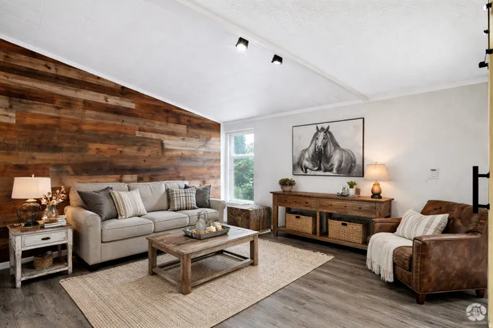 Living area featuring wood walls, lofted ceiling, and dark wood-style flooring