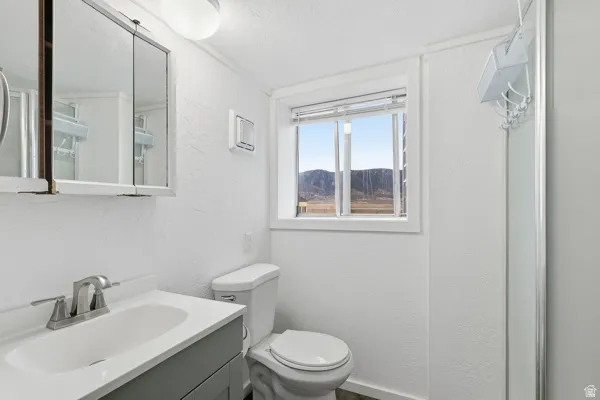 Bathroom with a textured wall, vanity, and a mountain view
