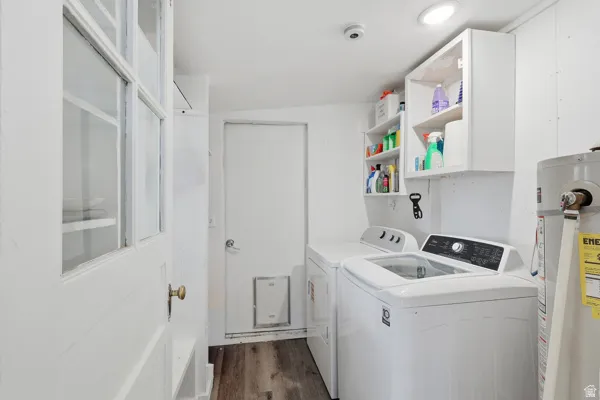 Laundry room featuring water heater, separate washer and dryer, plenty of storage