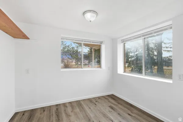 Spare room featuring light wood-type flooring and baseboards