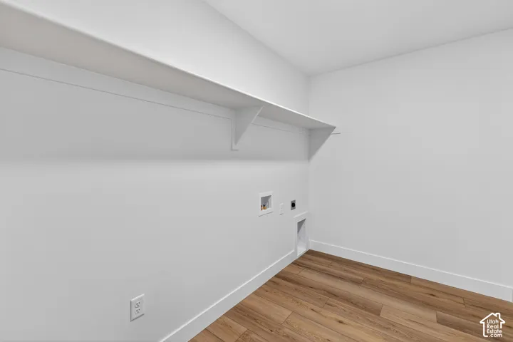 Laundry room with light wood-type flooring, hookup for an electric dryer, and washer hookup