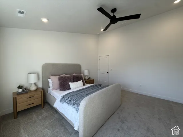 Recessed lighting, ceiling fan, neutral wall tones, white interior door, and textured carpeting