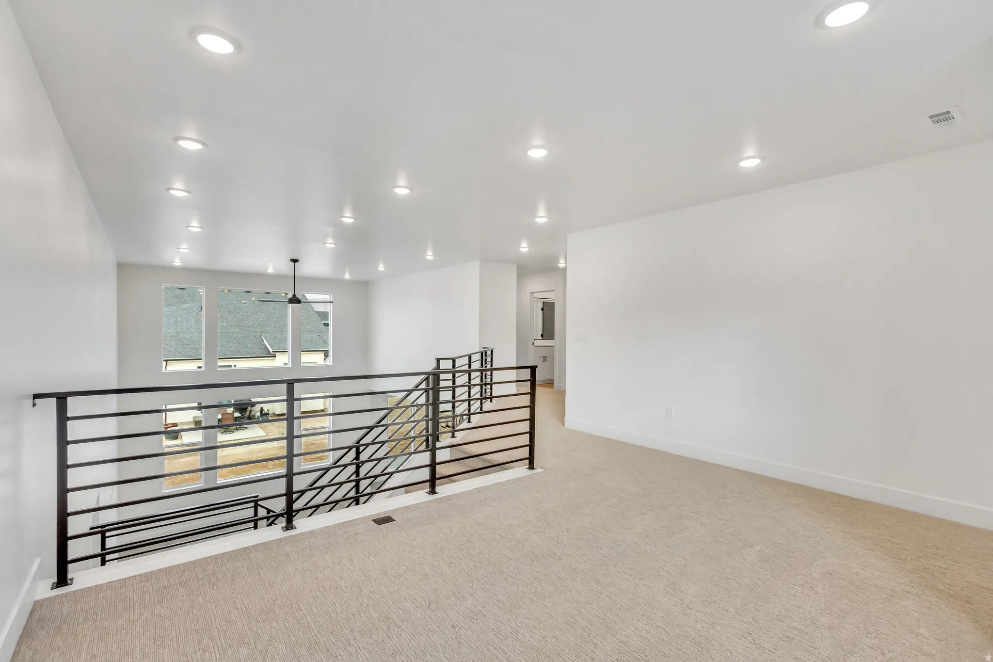Spare room featuring light colored carpet and recessed lighting