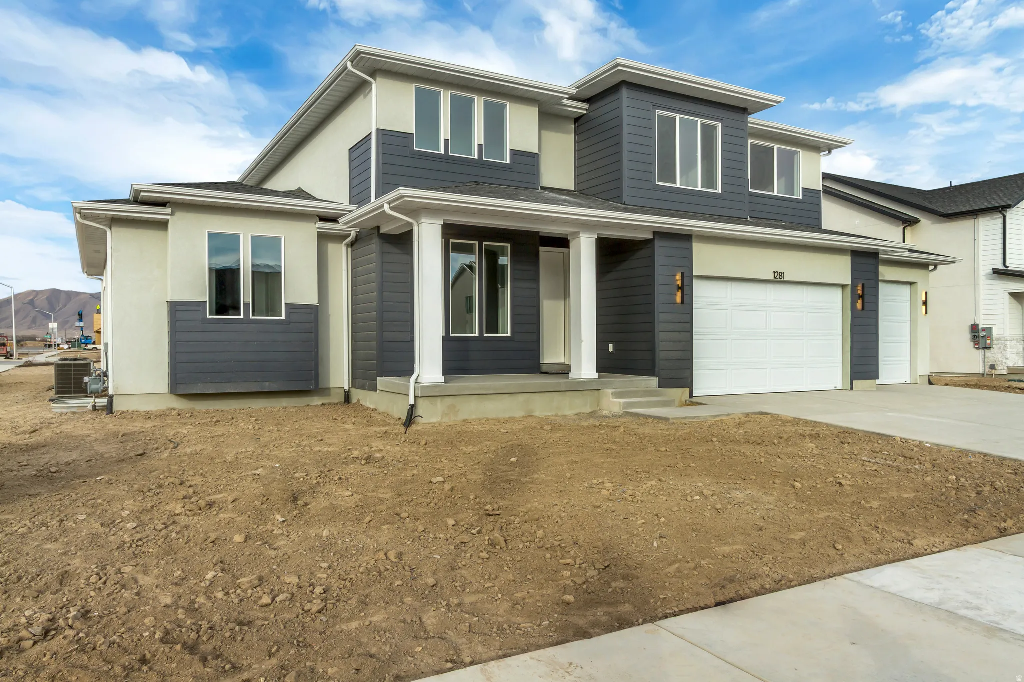View of front facade with covered porch, concrete driveway, and a garage