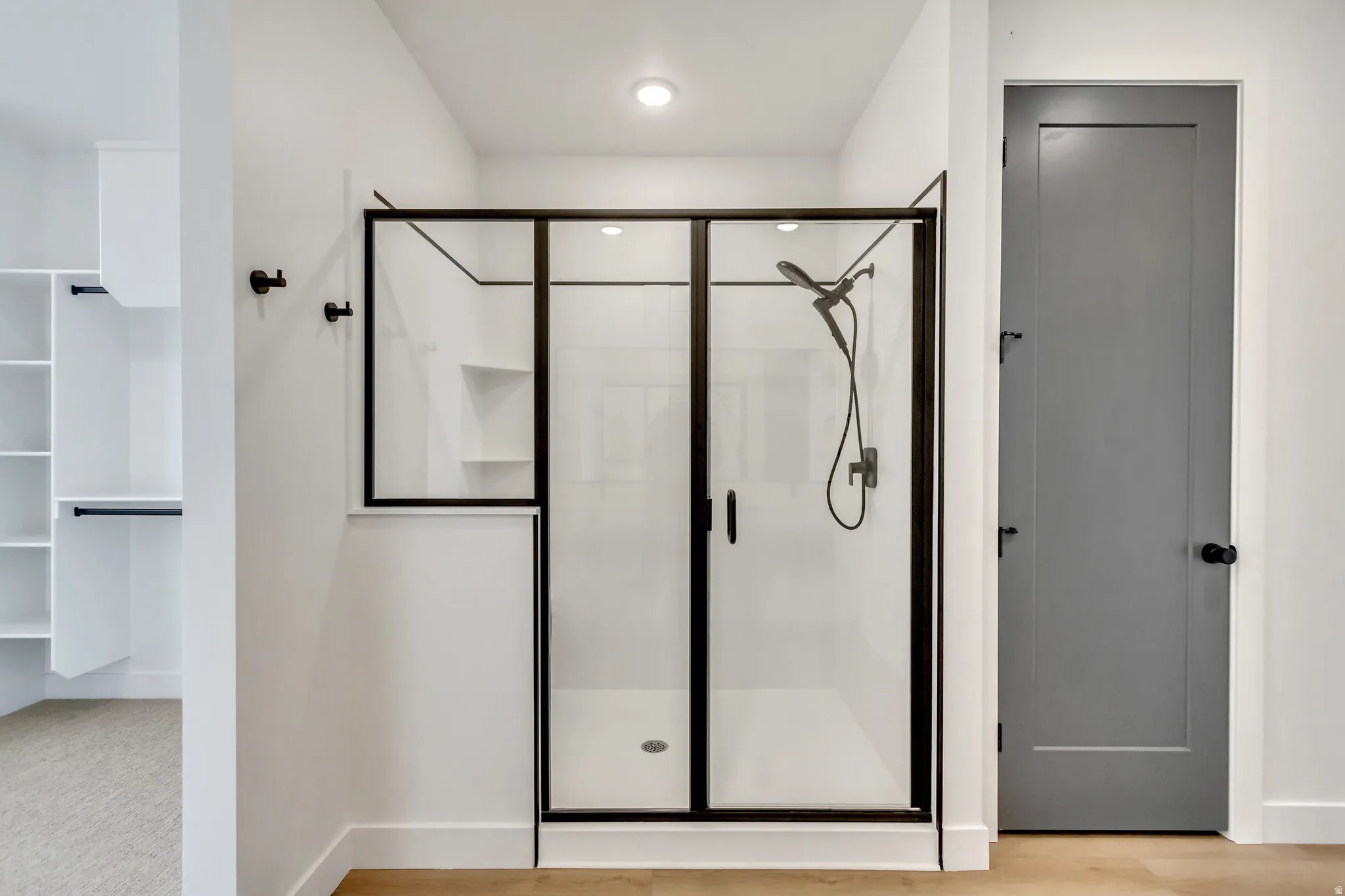 Full bath featuring a stall shower and a walk in closet