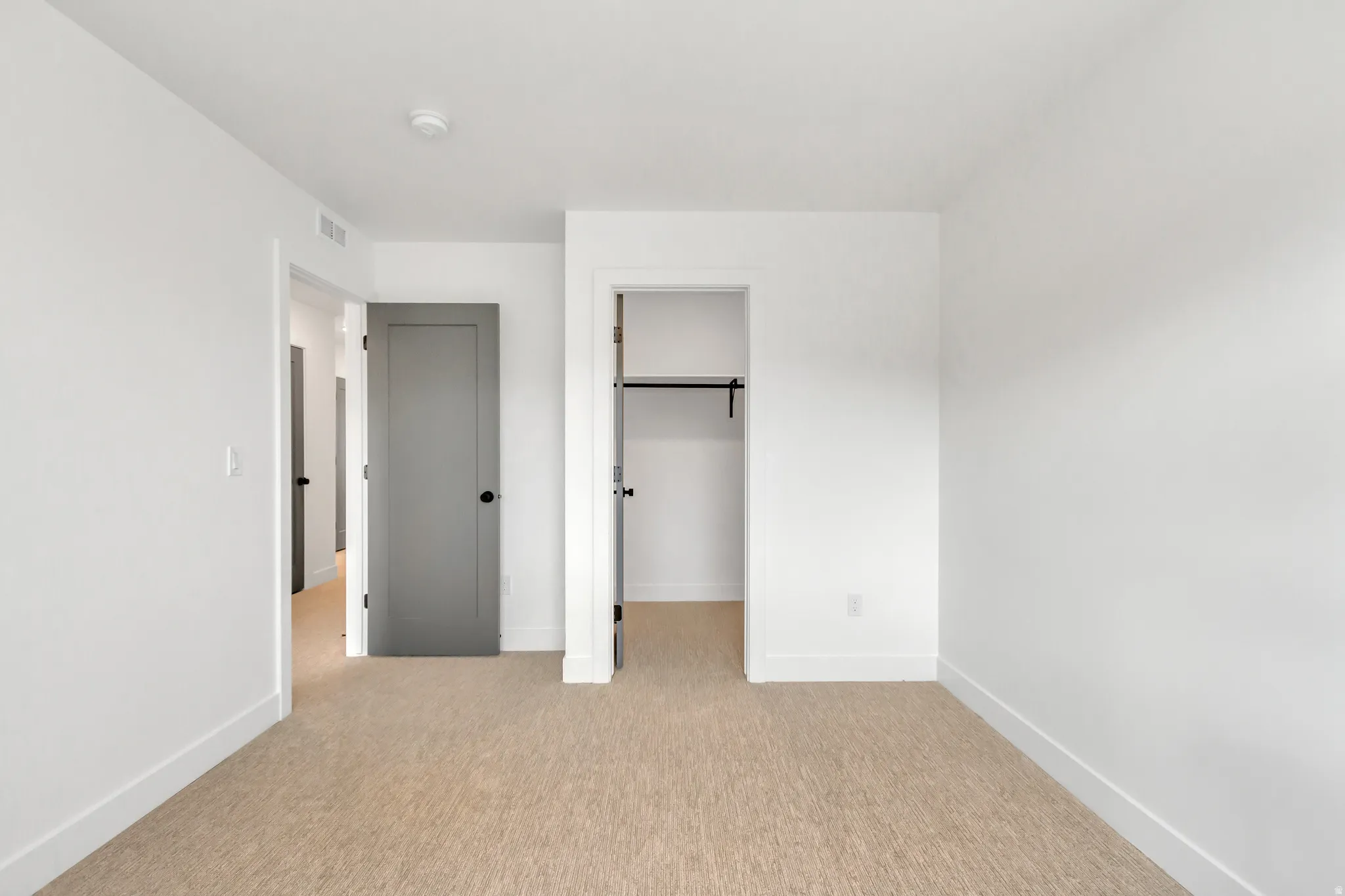 Unfurnished bedroom featuring a spacious closet and light carpet