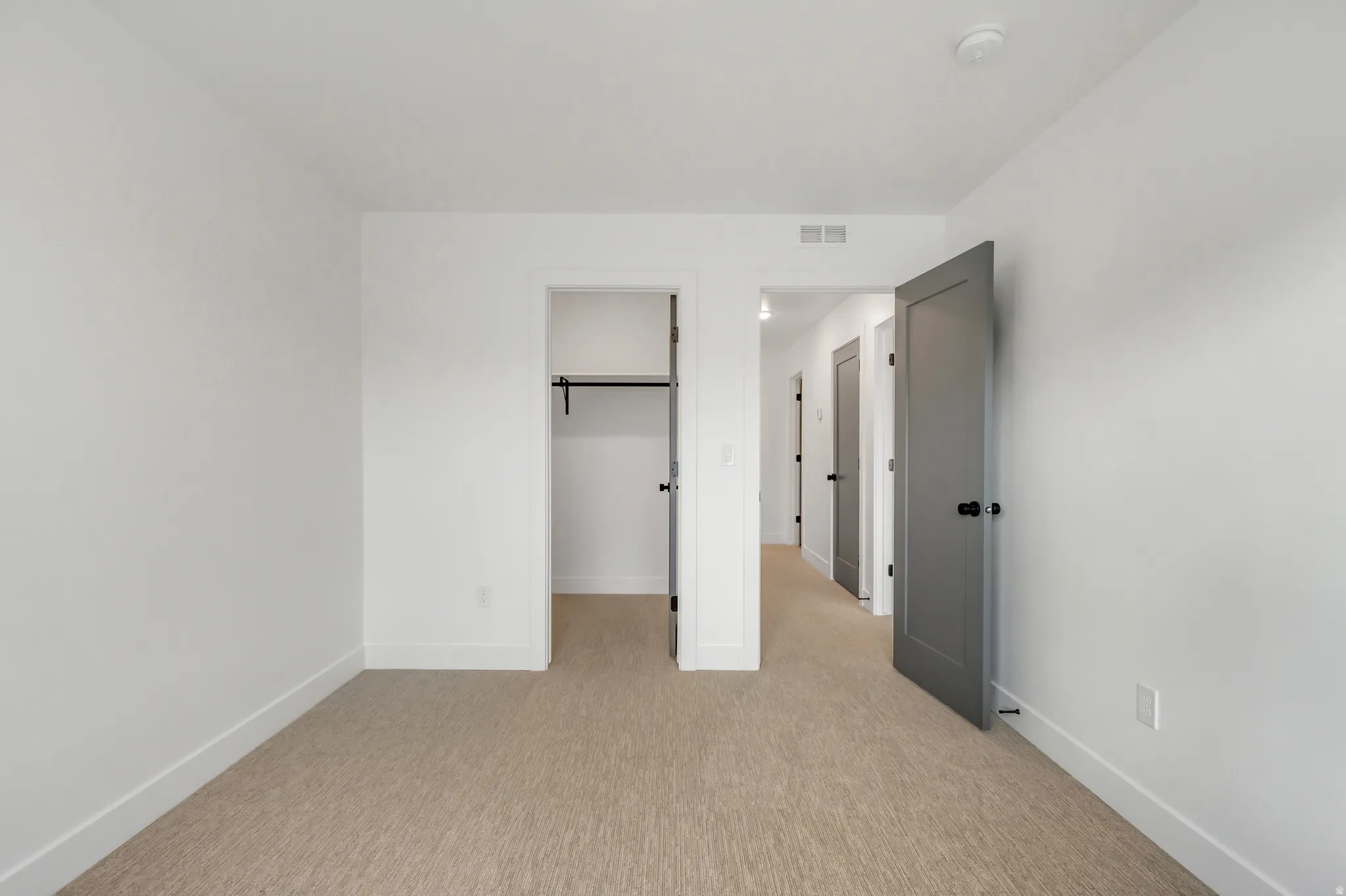 Unfurnished bedroom featuring a spacious closet and light carpet