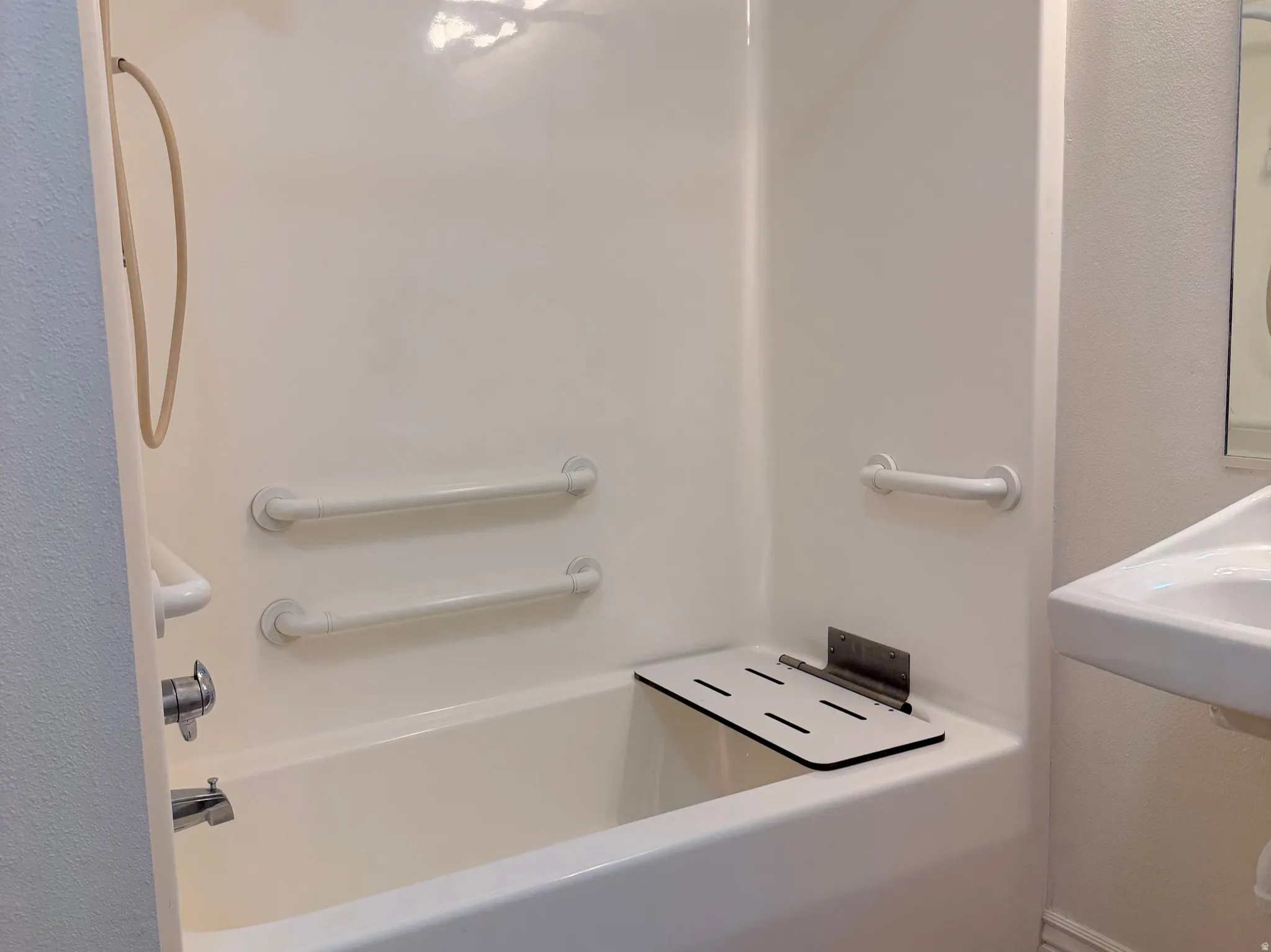 Full bath featuring tub/shower combination and a fold-down bench