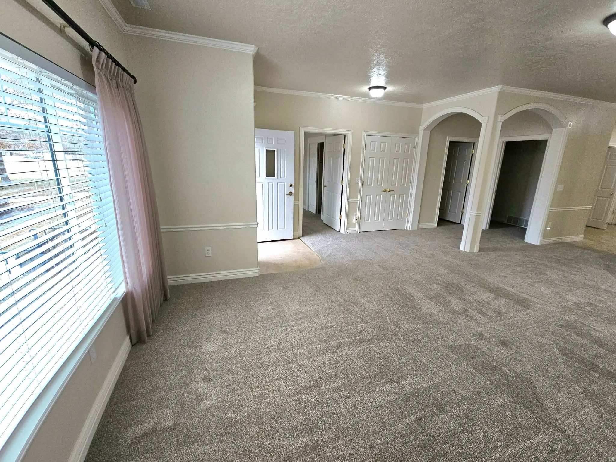 Living room with arched walkways and brand new carpet