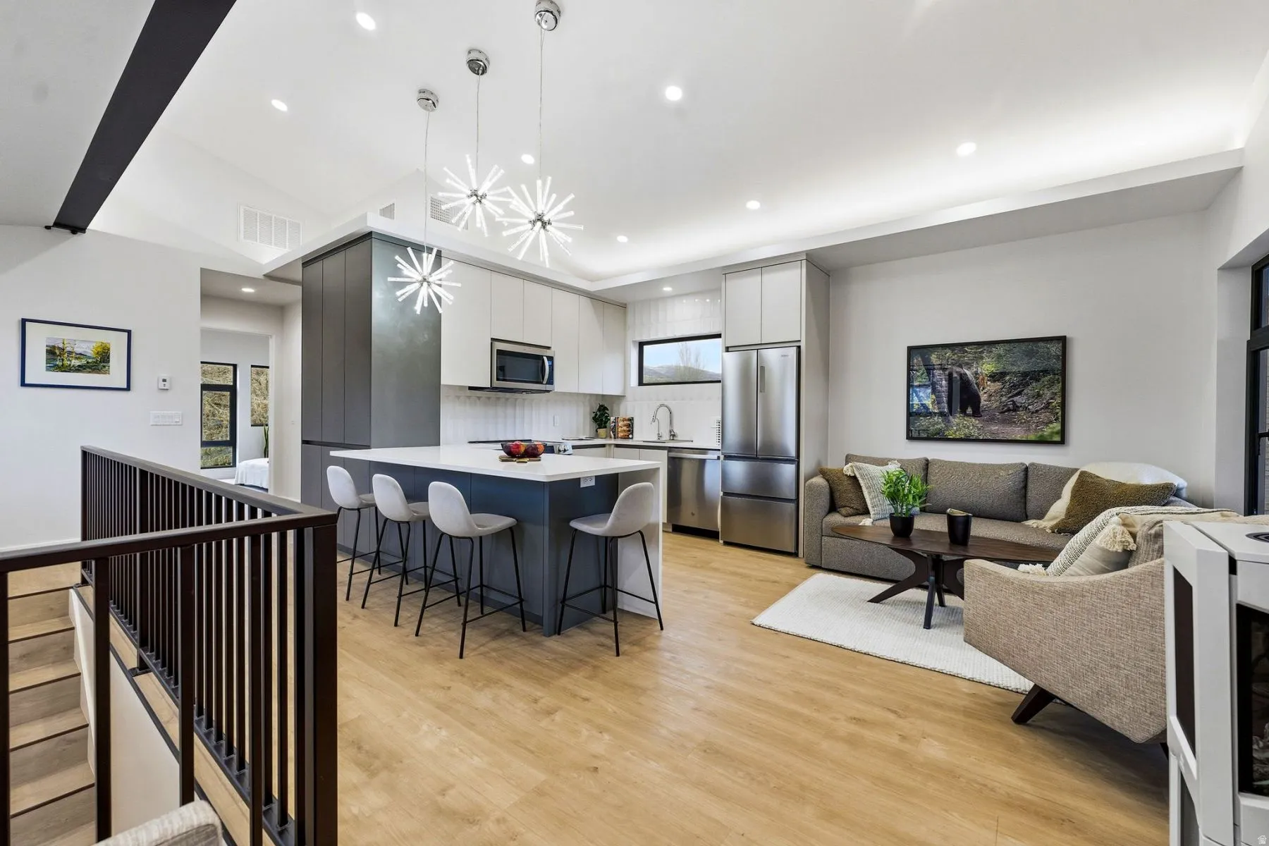 Kitchen featuring light countertops, a breakfast bar, stainless steel appliances, light wood-type flooring, and tasteful backsplash