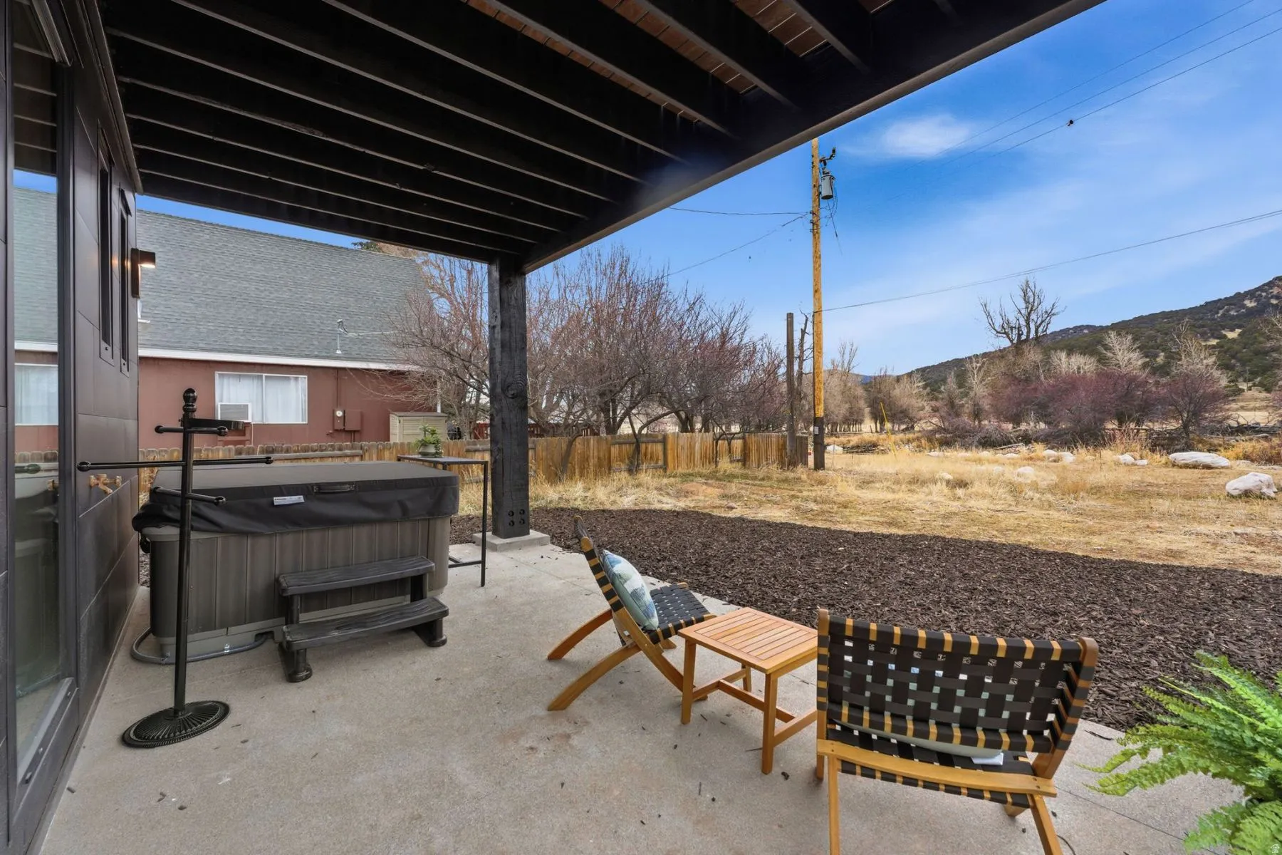 View of patio with a hot tub and a mountain view