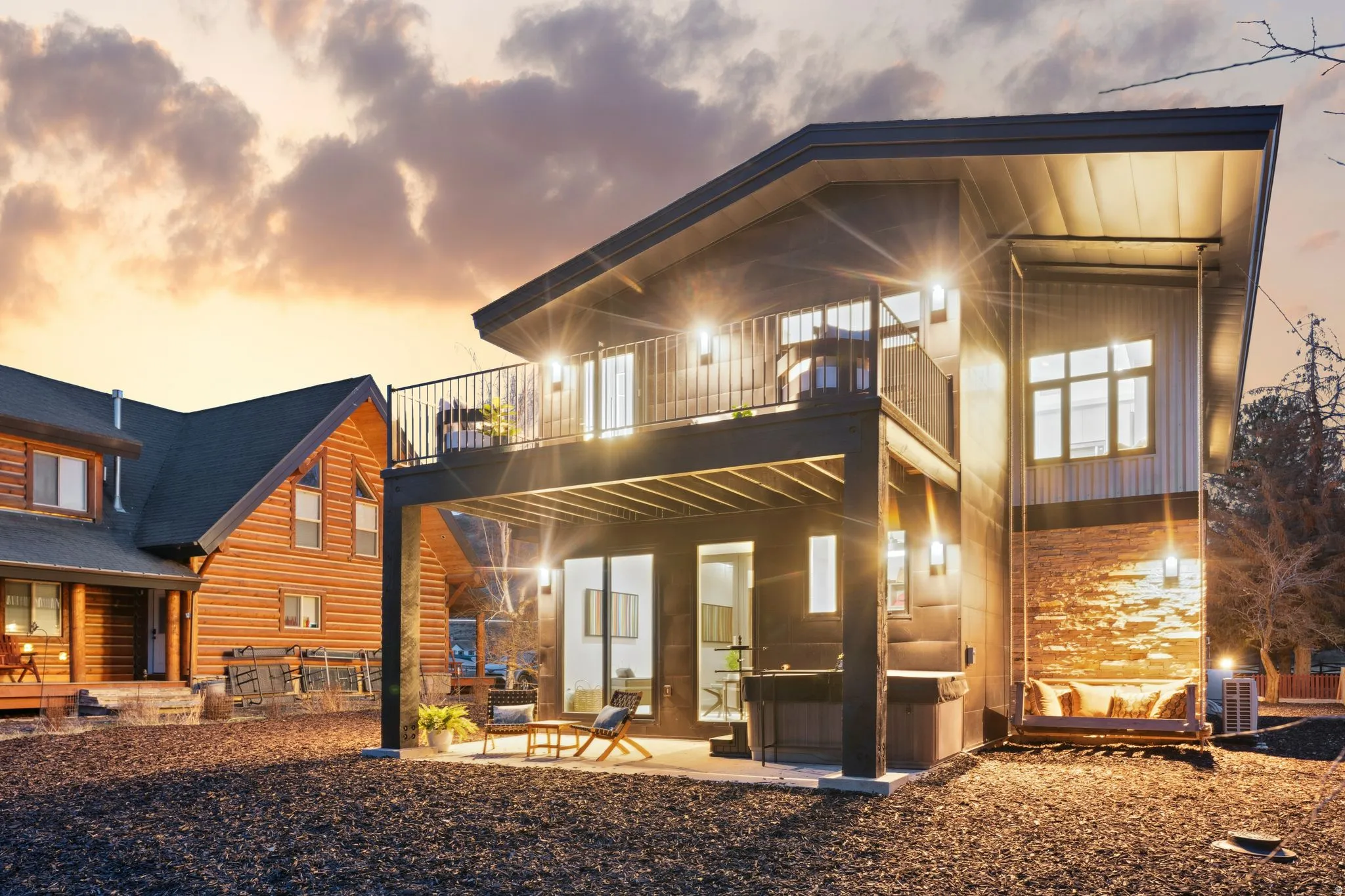Back of property at dusk with a patio area and a balcony
