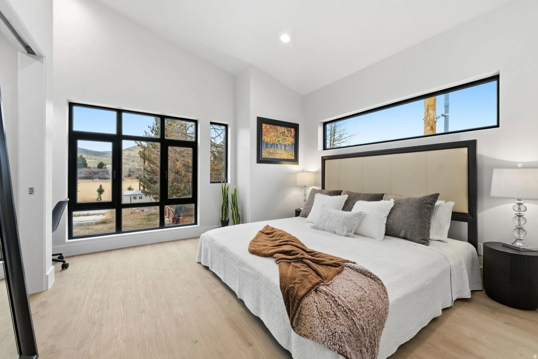 Bedroom with light wood finished floors, vaulted ceiling, and recessed lighting