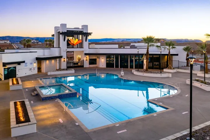Pool at dusk featuring a patio, a pool with connected hot tub, and a mountain view
