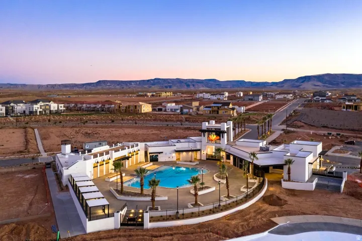 Pool at dusk with a community pool, a mountain view, and a patio