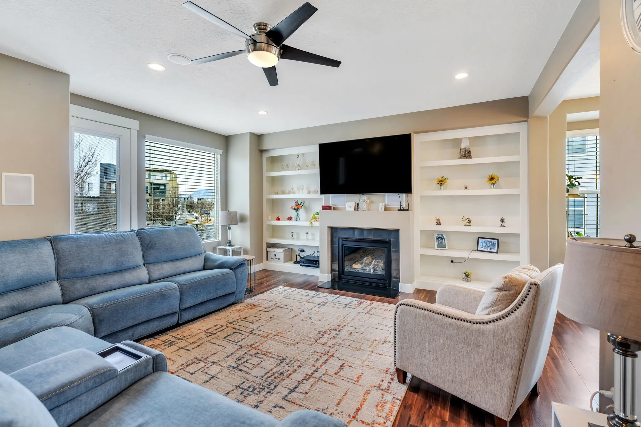 Living room with plenty of natural light, a ceiling fan, wood finished floors, and recessed lighting