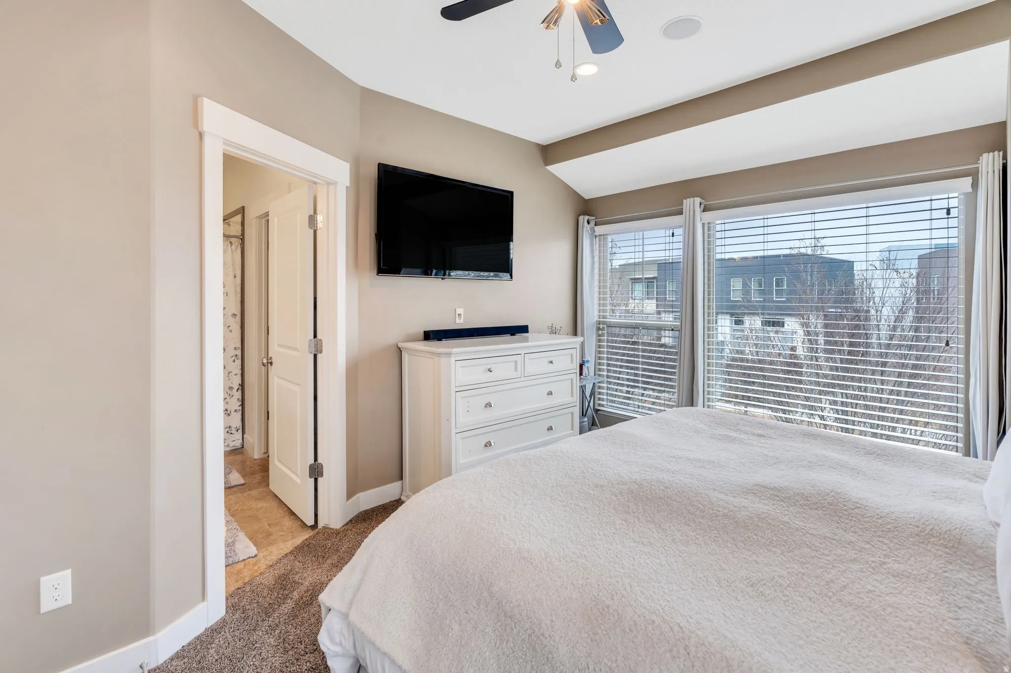 Bedroom featuring vaulted ceiling, ceiling fan, and dark carpet