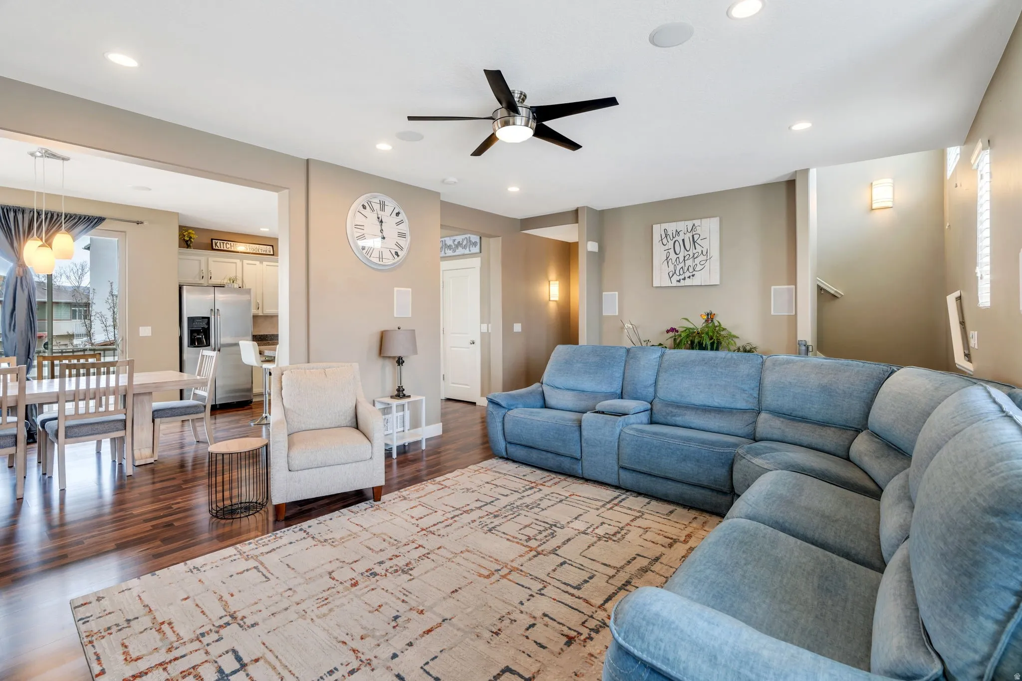 Living room with a ceiling fan, dark wood-type flooring, and recessed lighting