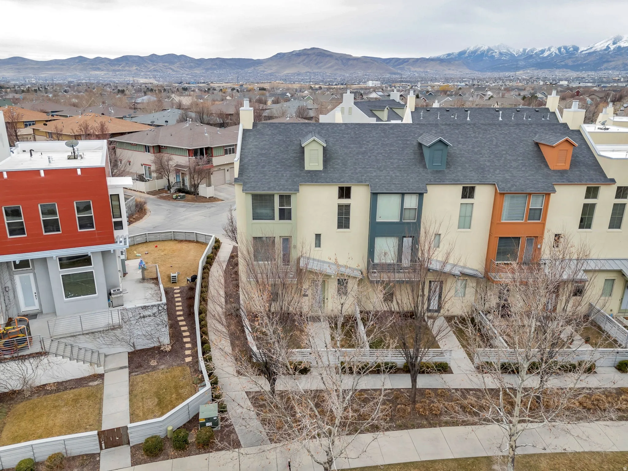 View of front of property with a chimney, stucco siding, a mountain view, a shingled roof, and a residential view