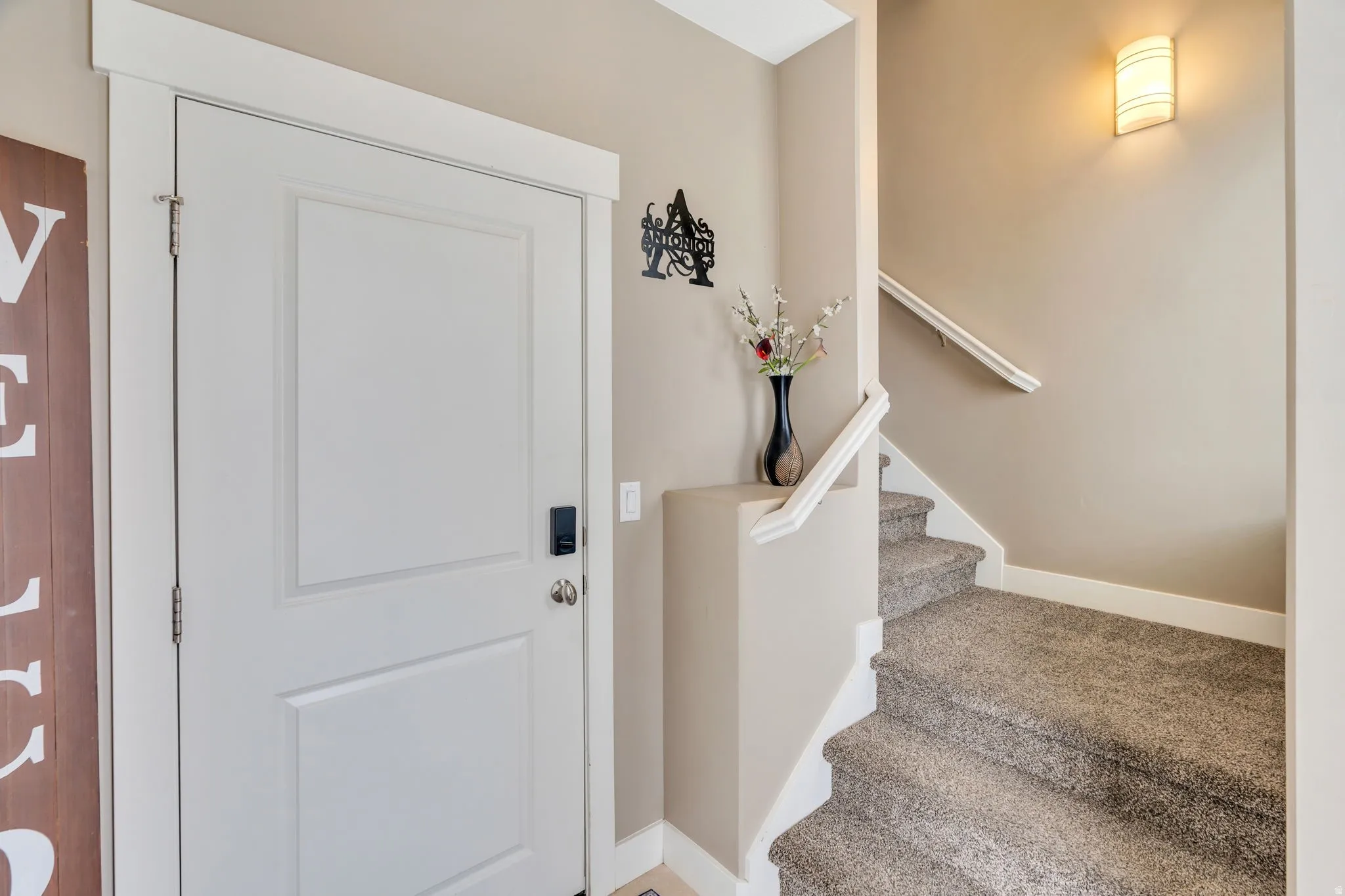 Carpeted entryway with stairs and baseboards