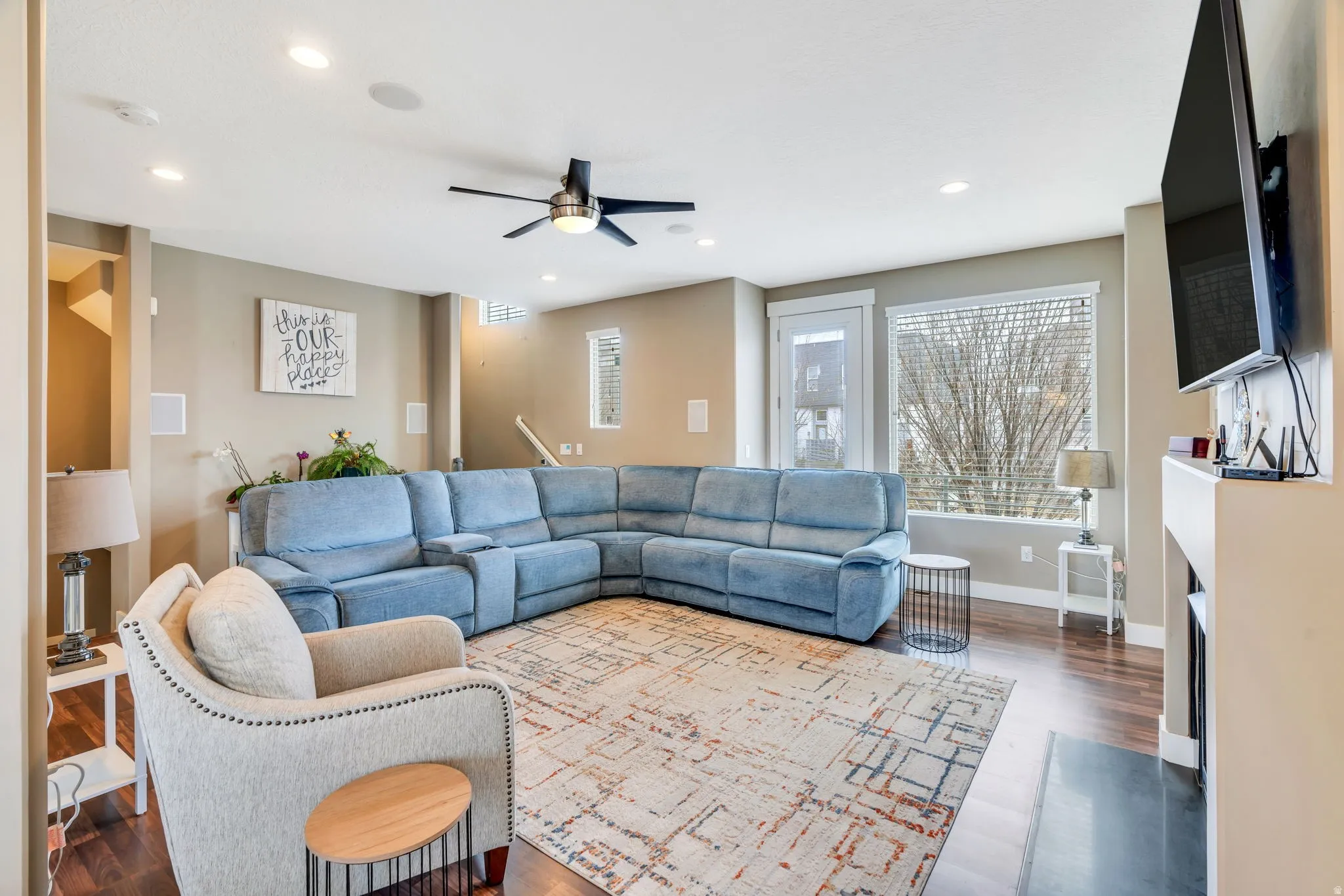 Living room featuring ceiling fan, recessed lighting, dark wood-style floors, and a fireplace