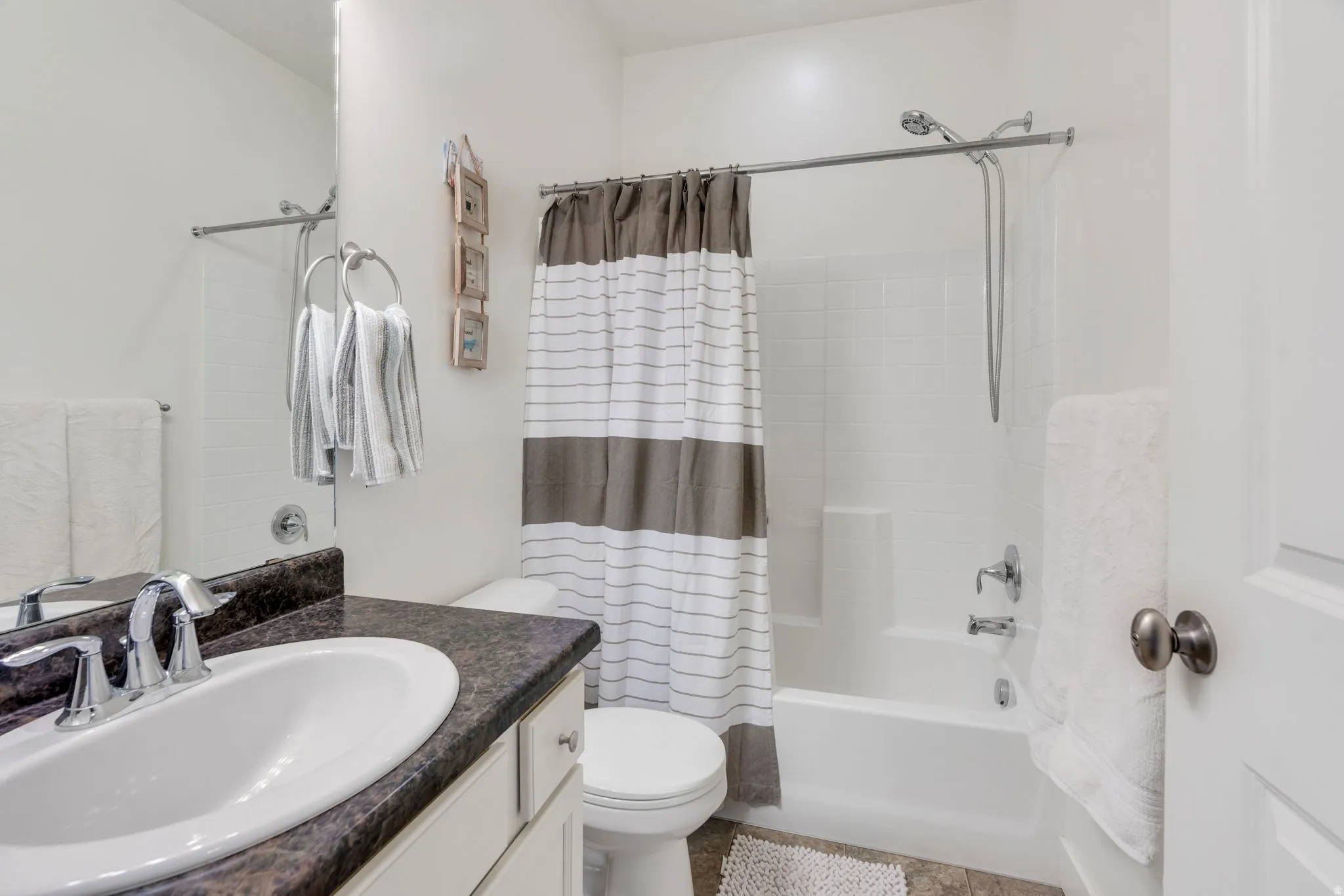 Bathroom featuring shower / bath combo with shower curtain and vanity