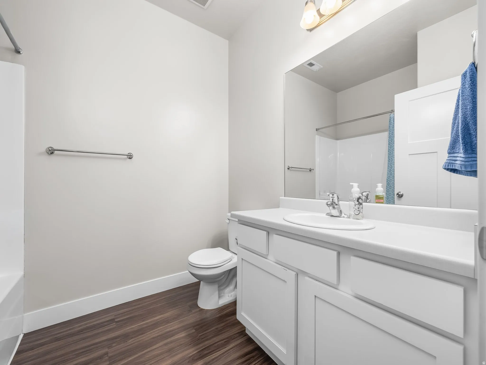 Bathroom featuring vanity,  wood-style floors, and bath tub / shower combination