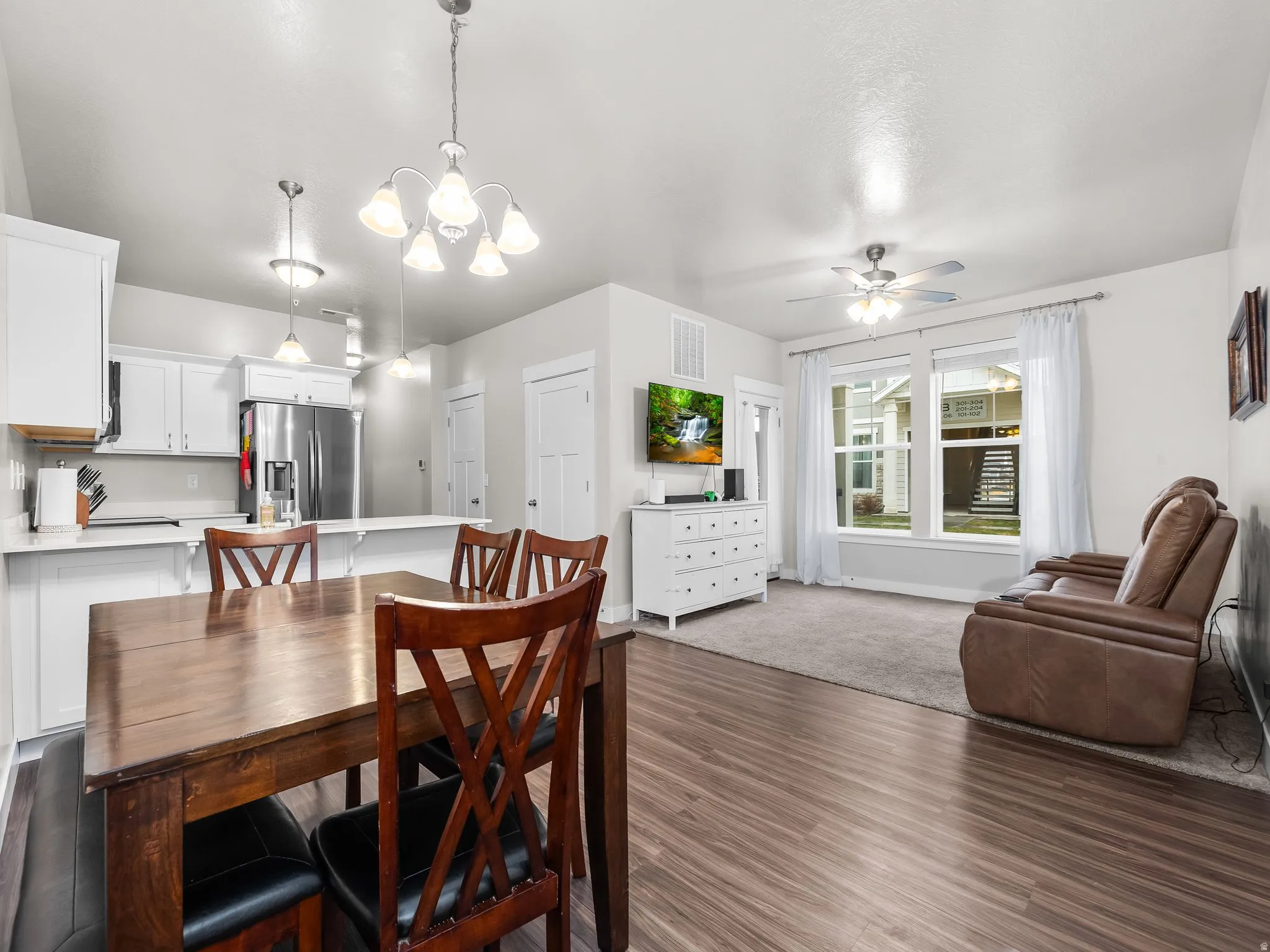 Dining room featuring wood-style floors, suspended lighting, and a ceiling fan