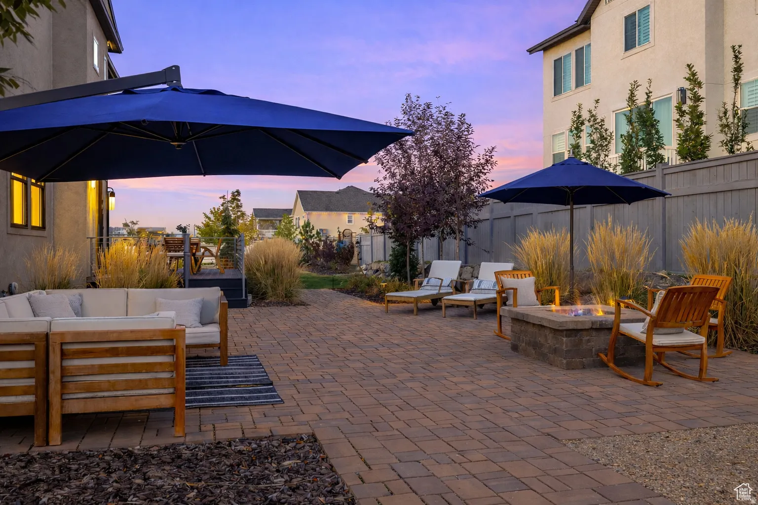 Patio terrace at dusk with a patio, a fenced backyard, and an outdoor living space with a fire pit