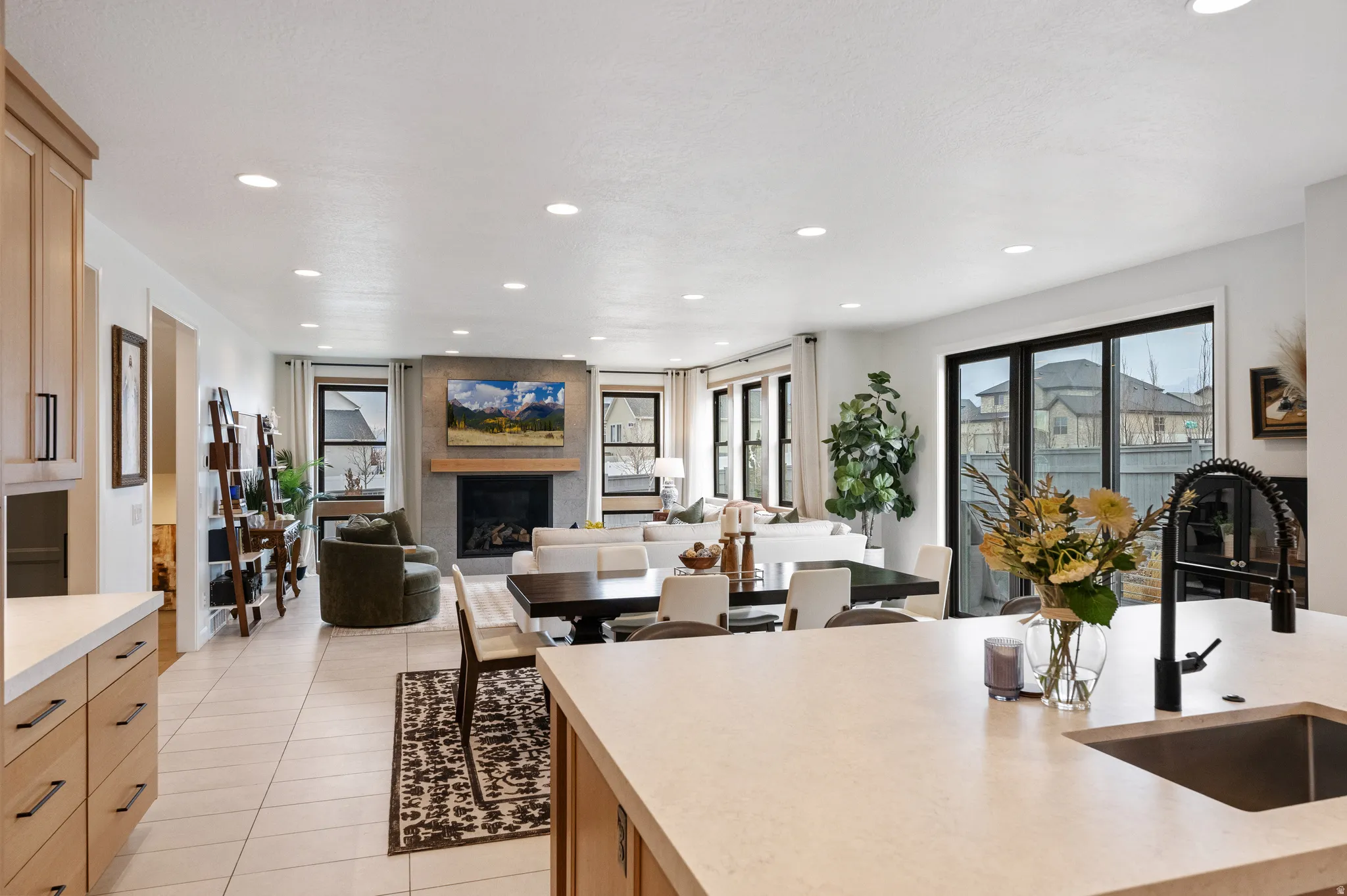 Kitchen with light wood finish cabinets, a large fireplace, healthy amount of natural light, recessed lighting, and open floor plan
