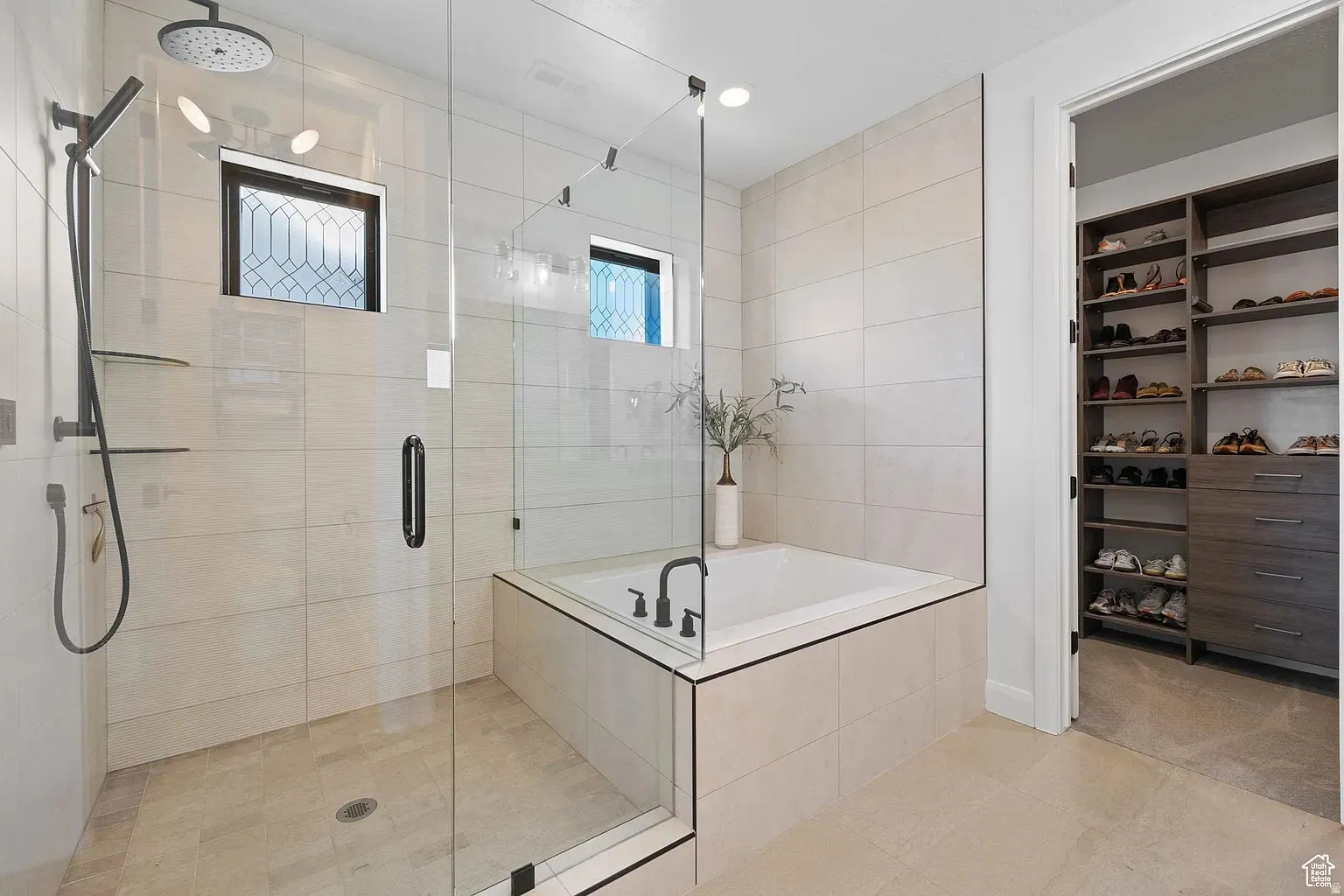 Full bathroom with a stall shower, a garden tub, a spacious closet, and light tile patterned flooring