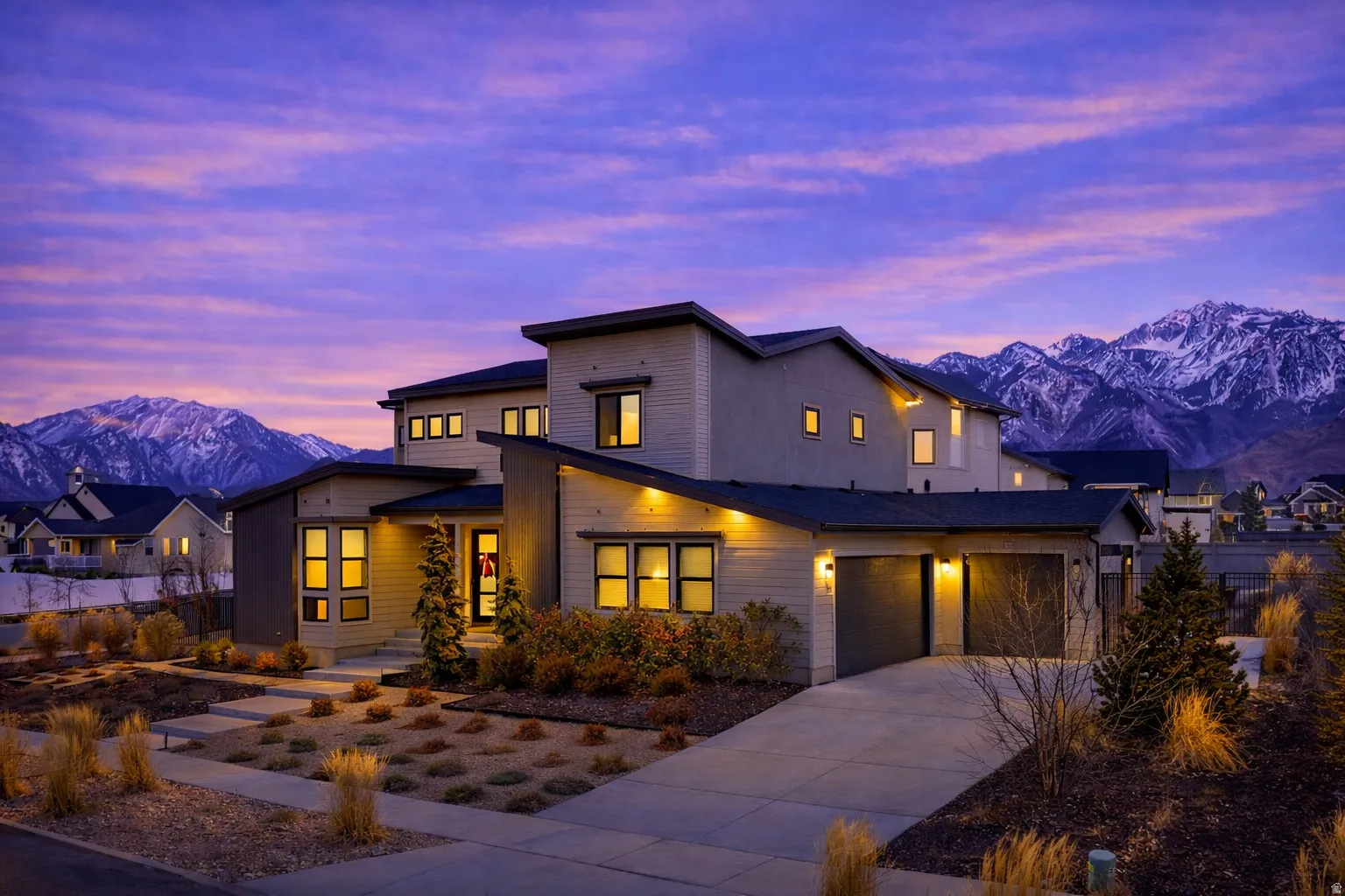 Modern home with beautiful mountain views, concrete driveway, and an attached large 3-car garage