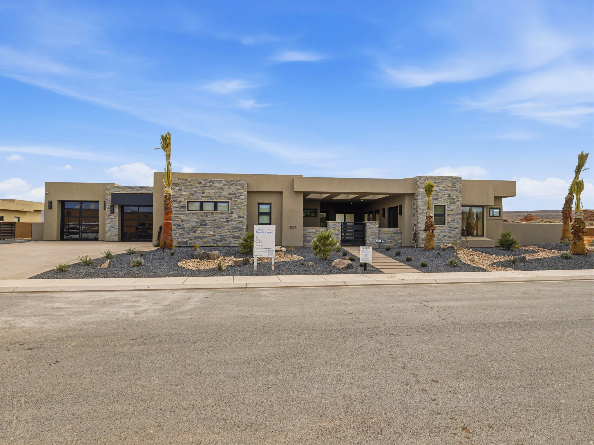 View of front of property with stone siding, stucco siding, concrete driveway, and an attached garage